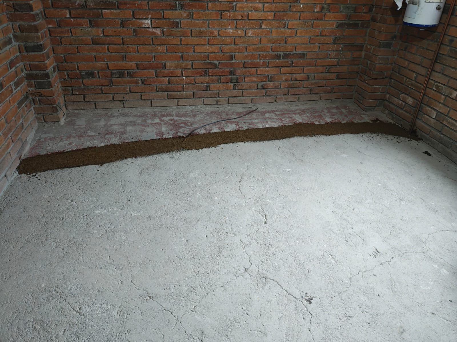 4. Aplicación de la capa base epóxica. Se aplica una capa de resina epóxica sobre el concreto preparado. Esta capa funciona como base de adherencia y proporciona el color de fondo del acabado.